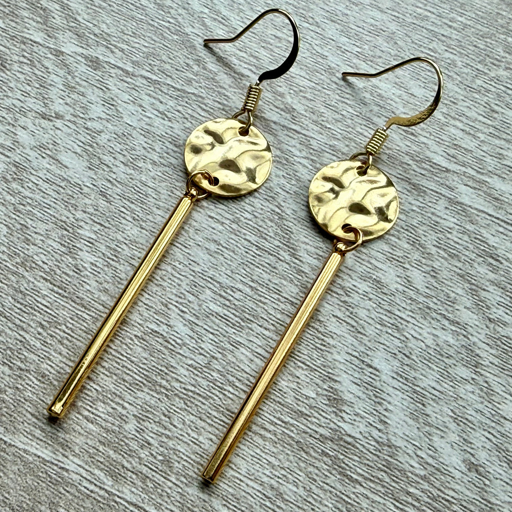 Gold hammered disc with dangle bar.